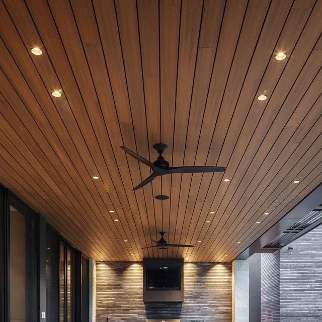 Covered patio with warm wood tongue-and-groove ceiling, recessed LED lighting, and dual matte black ceiling fans